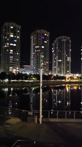 Nighttime photography session captures illuminated Kyiv waterfront and residential buildings