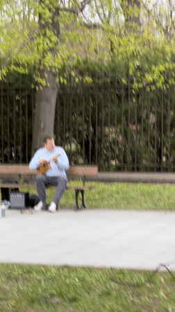 Street musician plays ukulele in Warsaw park