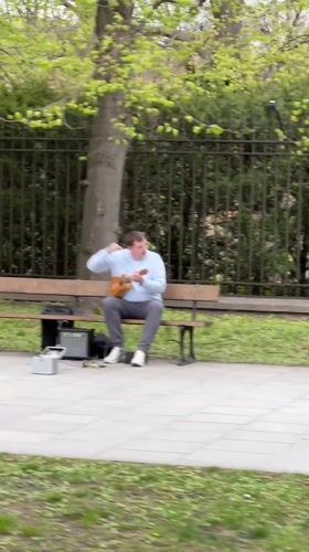 Street musician plays ukulele in Warsaw park
