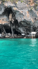 Sea cave entrance in Ao Nang's limestone cliffs, approached by boat