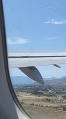 Aircraft passenger observes wing and landscape over Golubovci, Montenegro