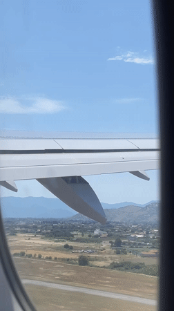 Aircraft passenger observes wing and landscape over Golubovci, Montenegro