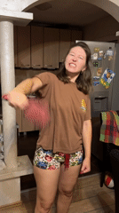 Woman plays with hairbrush in Podgorica kitchen
