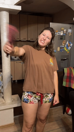 Woman plays with hairbrush in Podgorica kitchen