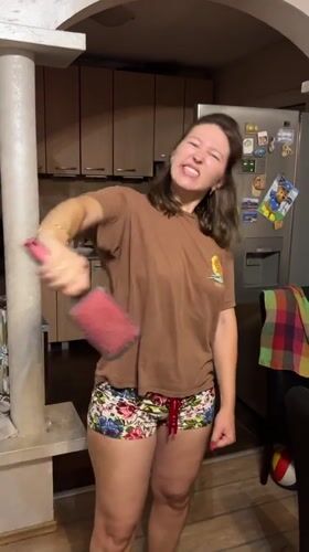 Woman plays with hairbrush in Podgorica kitchen