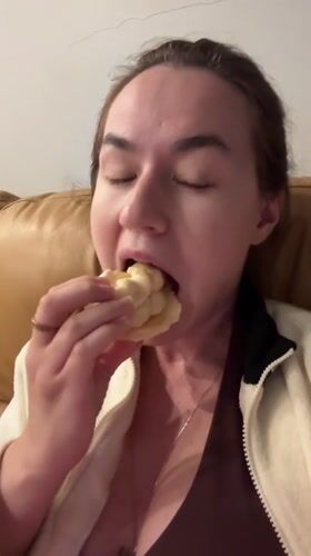 Woman enjoys pastry on couch in Rawai, Thailand