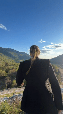 Woman celebrates on hilltop overlooking valley in Montenegro