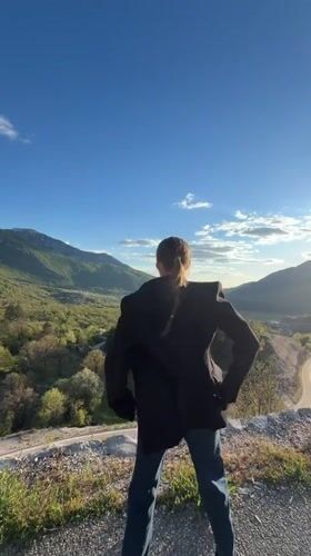 Woman celebrates on hilltop overlooking valley in Montenegro