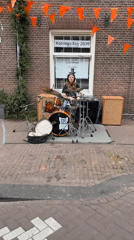 Young drummer performs street set on Amsterdam sidewalk