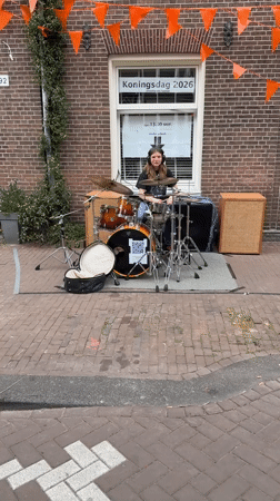 Young drummer performs street set on Amsterdam sidewalk