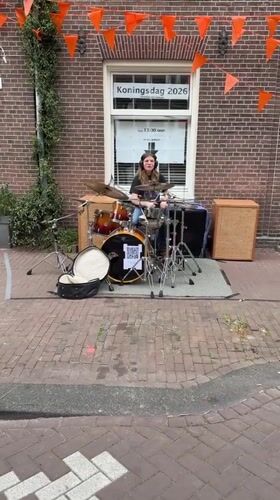 Young drummer performs street set on Amsterdam sidewalk