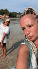 Two women take selfies during early morning Jimbaran beach visit