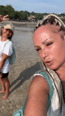 Two women take selfies during early morning Jimbaran beach visit
