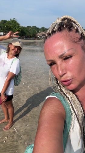 Two women take selfies during early morning Jimbaran beach visit