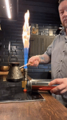 Man uses blowtorch to prepare coffee in Russian kitchen