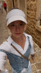 Young woman explores historic Budva streets, captures coastal views