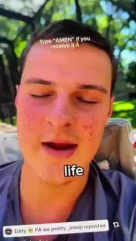 A man with short brown hair and blemishes on his face is looking directly at the camera. He is wearing a grey athletic shirt. He is speaking to the camera, and the text "turn", "good", "enemy", "them", "them" appears on screen. The video is shot outside, likely in a yard with green trees visible in the background. There is text at the top of the screen that reads, "type 'AMEN' if you receive it 🙏." At the bottom left corner of the screen, a username that appears to read "Eddy" is visible, along with "PA wa pretty_emoji reposted."