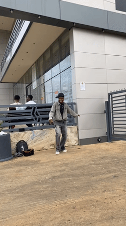 Street dancer performs outside modern building in Bukuru, Nigeria