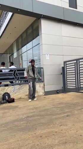 Street dancer performs outside modern building in Bukuru, Nigeria
