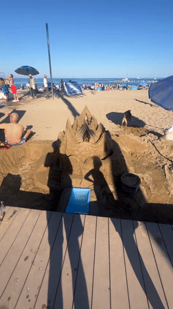 Busy beach day documented across Barcelona waterfront during afternoon hours