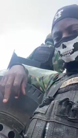 The video shows several soldiers wearing camouflage uniforms and vests. Some wear hats with “SF” on them. One soldier has a skull design on their mask. The soldiers are on a boat in a body of water. Some hold rifles. The sky is visible and there are some clouds.
