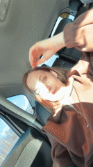 Woman in car passenger seat touches forehead in Russia