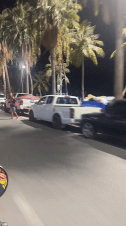 Motorcyclist rides through nighttime Pattaya streets amid traffic