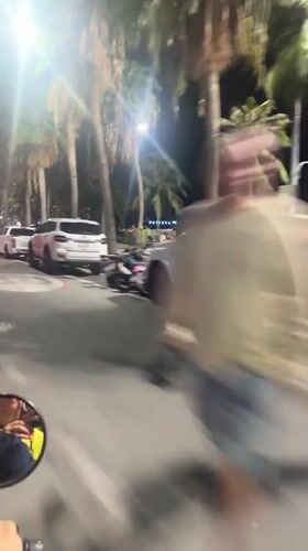 Motorcyclist rides through nighttime Pattaya streets amid traffic