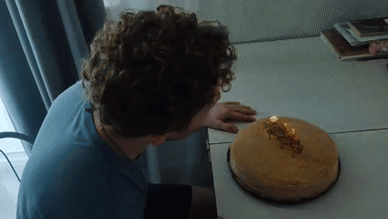 Russian birthday party with cake, candles, and fairy-lit decor