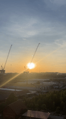 Sunrise captured between construction cranes in Pattaya City