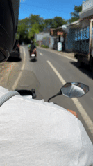 Two motorcyclists ride together on paved road early morning