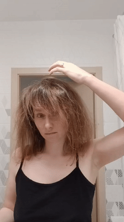 Woman dries hair in Yekaterinburg bathroom