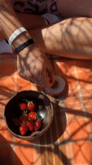 Man dips strawberry in white substance, displays to camera