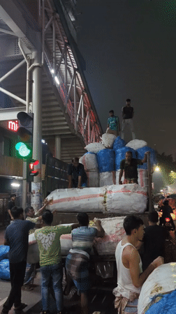 Workers load cargo onto trucks across Dhaka locations