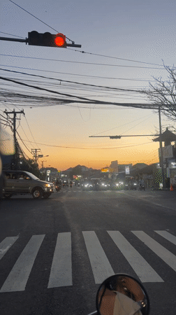 SUV makes left turn at Denpasar intersection during sunset