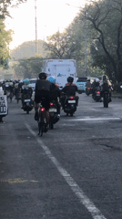 Evening traffic builds on a Gelam road with motorcycles and trucks
