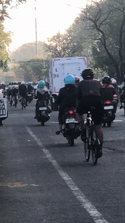 Evening traffic builds on a Gelam road with motorcycles and trucks