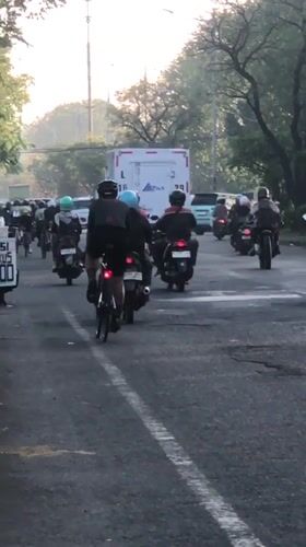 Evening traffic builds on a Gelam road with motorcycles and trucks