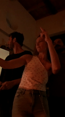 Woman films with phone in dimly lit Tel Aviv room