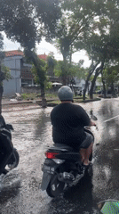 Motorcyclists navigate flooded Kuta streets after heavy rainfall