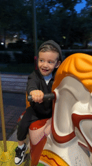 Child enjoys evening carousel ride in Razgrad, Bulgaria