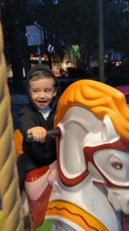 Child enjoys evening carousel ride in Razgrad, Bulgaria