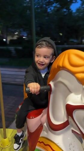 Child enjoys evening carousel ride in Razgrad, Bulgaria
