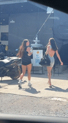 Two women walk past Legacy Shop in Choeng Mon