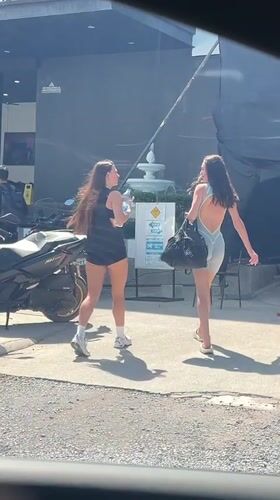 Two women walk past Legacy Shop in Choeng Mon