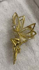 Flat-lay of jewelry, cosmetics, and trinkets on white fabric