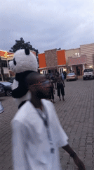 Panda costume performer encounters two men in Jos Nigeria