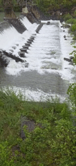Water flows over concrete weir in Villanova, Spain