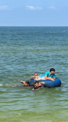 Group swimming and floating on an inflatable tube off Khan Yunis