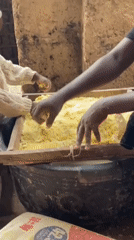 Child helps adults process grain in Nigerian community operation